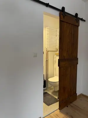 a bathroom with a toilet and a wooden door at Ojców, Na Widoku in Ojców