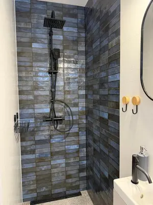 a shower in a bathroom with a tile wall at Ojców, Na Widoku in Ojców