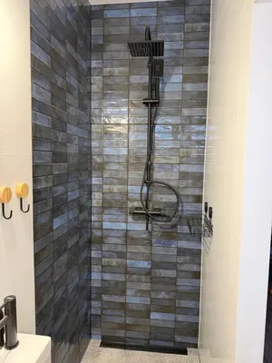 a shower in a bathroom with a gray tiled wall at Ojców, Na Widoku in Ojców