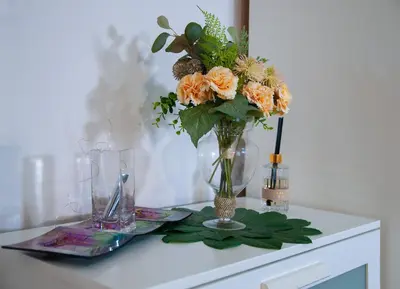 a vase filled with flowers on a table at Cozy Apartament Rachel-Near Rynek Netflix in Kraków