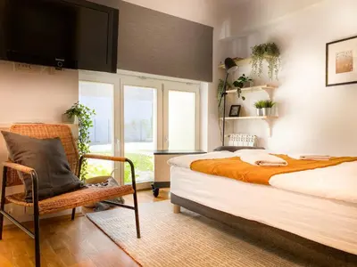 a bedroom with a large bed and a chair at Charming Studio for couples in the heart of Cracow in Kraków