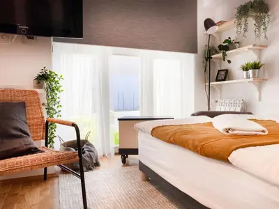 a bedroom with a bed and a chair and a window at Charming Studio for couples in the heart of Cracow in Kraków