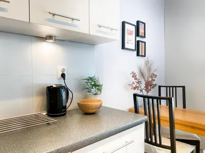 a kitchen with a counter with a coffee maker and a table at Charming Studio for couples in the heart of Cracow in Kraków