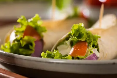 a sandwich on a plate with lettuce and carrots at Charming Studio for couples in the heart of Cracow in Kraków