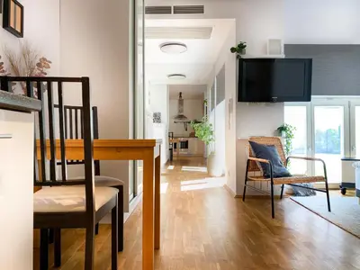 a living room with a table and chairs and a tv at Charming Studio for couples in the heart of Cracow in Kraków
