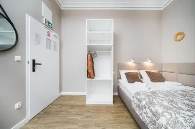 a small bedroom with a bed and a closet at Bagel Residence Old Town in Kraków