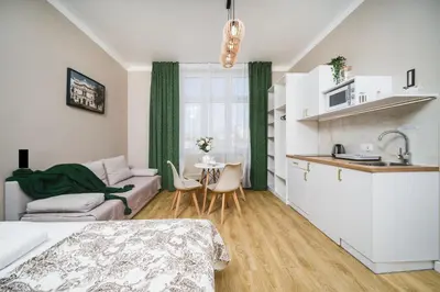 a kitchen and living room with a couch and a table at Bagel Residence Old Town in Kraków