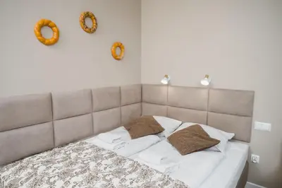 a bed with two pillows and two wreaths on the wall at Bagel Residence Old Town in Kraków