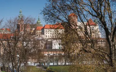 a large building with trees in front of it at Bagel Residence Old Town in Kraków