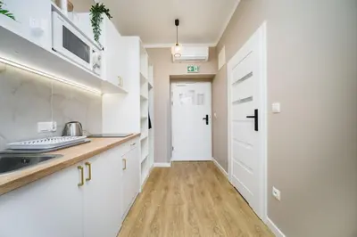 a kitchen with white cabinets and a sink at Bagel Residence Old Town in Kraków