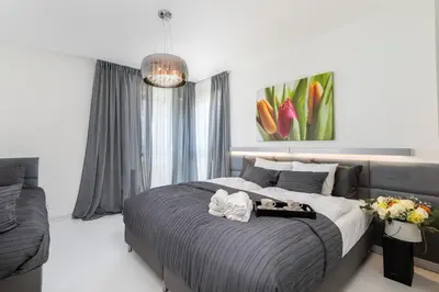 a bedroom with a large bed and a couch at Ekskluzywny Apartament Garden Residence *Basen/Siłownia* in Kraków
