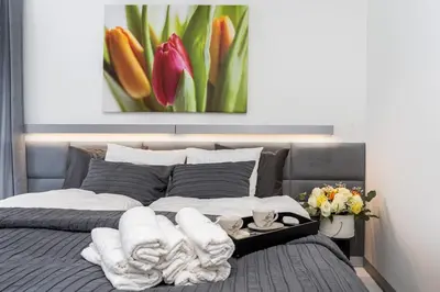 a bedroom with a bed with a painting on the wall at Ekskluzywny Apartament Garden Residence *Basen/Siłownia* in Kraków