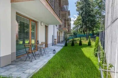 a patio with grass and a table and chairs at Prestigious Residence with Garden, Garage, and Elegant Rooms in Kraków