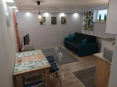 a living room with a table and a blue couch at Studio Familly-nocleg-Zator- Wadowice-Oświęcim-Kraków in Bachowice