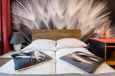 a bedroom with a bed with a wall with feathers at Apartament Dębnicki WAWELOFTS in Kraków