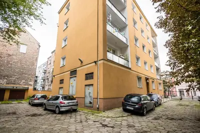 a building with cars parked in front of it at Apartament Dębnicki WAWELOFTS in Kraków