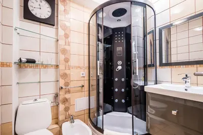 a bathroom with a toilet and a sink and a clock at Apartament Dębnicki WAWELOFTS in Kraków