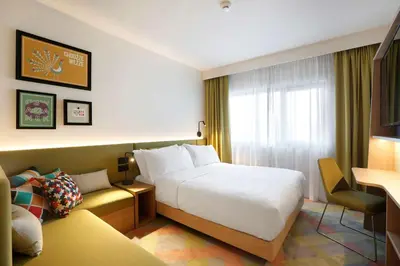 a hotel room with a bed and a window at Hampton by Hilton Krakow Airport in Balice