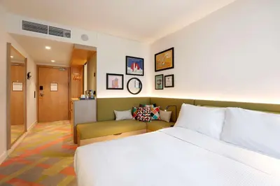 a hotel room with a bed and a couch at Hampton by Hilton Krakow Airport in Balice