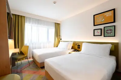 a hotel room with two beds and a window at Hampton by Hilton Krakow Airport in Balice