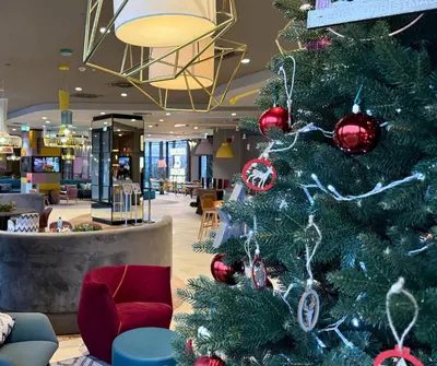 a lobby with a bar and a red chair at Hampton by Hilton Krakow Airport in Balice