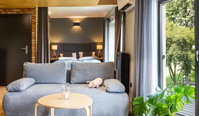a living room with a couch and a bed at H&G Boutique Apartments in Oświęcim