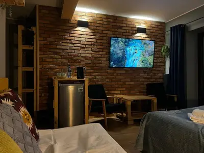 a living room with a tv on a brick wall at H&G Boutique Apartments in Oświęcim
