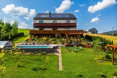 a house with a swimming pool in a garden at Apartamenty Black Lion in Pcim