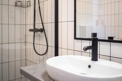 a white sink in a bathroom with a shower at Apartamenty Black Lion in Pcim