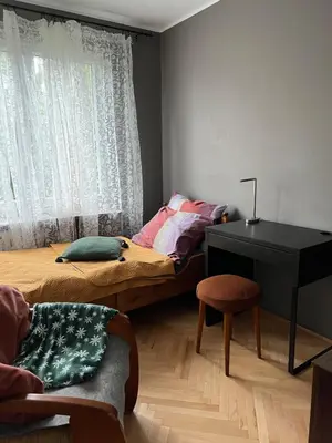 a bedroom with a bed and a desk and a window at u cioci Lutki urocze mieszkanie z balkonem in Kraków