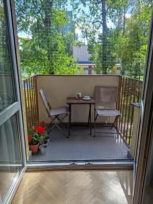 a patio with a table and chairs on a balcony at u cioci Lutki urocze mieszkanie z balkonem in Kraków