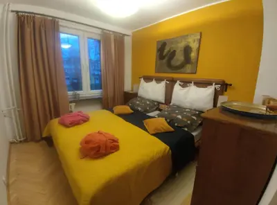 a hotel room with a large bed with yellow sheets at u cioci Lutki urocze mieszkanie z balkonem in Kraków
