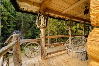 a wooden playground with a slide in front of a forest at Bacówka Polanki in Obidowa