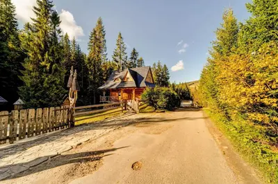 a wooden bench in front of a log cabin at Bacówka Polanki in Obidowa