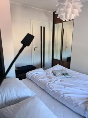 a bedroom with a white bed and a lamp at Apartament Limanowa Rynek in Limanowa