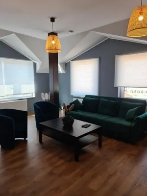 a living room with a green couch and a coffee table at Apartament Limanowa Rynek in Limanowa