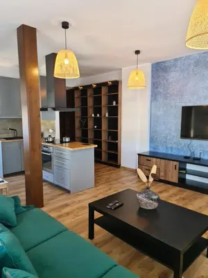 a living room with a green couch and a table at Apartament Limanowa Rynek in Limanowa
