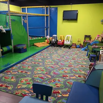 a room with a rug on the floor with chairs and a play area at Apartament Limanowa Rynek in Limanowa