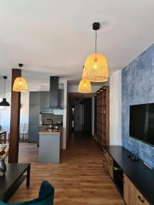 a kitchen and living room with two pendant lights at Apartament Limanowa Rynek in Limanowa