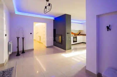 a living room with purple walls and a kitchen at Apartament Izabel in Nowy Targ