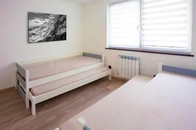 a bedroom with two beds and a window at Apartament Izabel in Nowy Targ