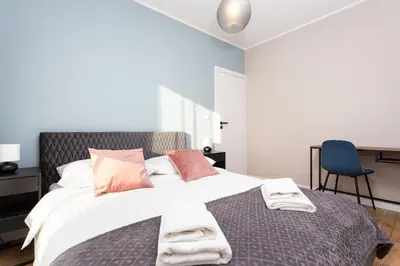 a bedroom with a large bed with towels on it at City of the Kings - Indigo Apartment in Kraków