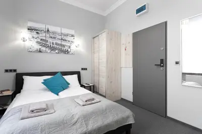 a bedroom with a bed with blue pillows on it at DAVE Elegant Apartments KRAKÓW Old Town in Kraków