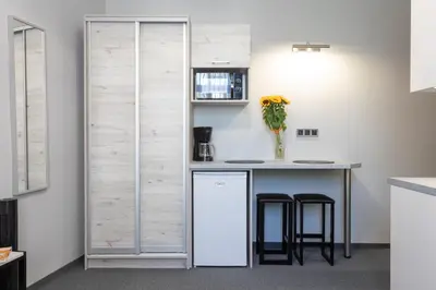 a kitchen with a refrigerator and a counter with stools at DAVE Elegant Apartments KRAKÓW Old Town in Kraków