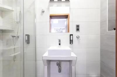 a white bathroom with a sink and a shower at DAVE Elegant Apartments KRAKÓW Old Town in Kraków