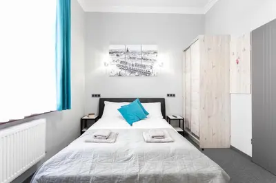 a bedroom with a bed with blue pillows on it at DAVE Elegant Apartments KRAKÓW Old Town in Kraków