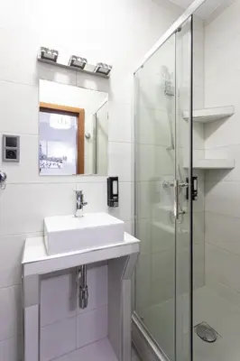 a white bathroom with a sink and a shower at DAVE Elegant Apartments KRAKÓW Old Town in Kraków