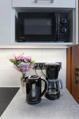 a kitchen counter with two coffee makers and a microwave at DAVE Elegant Apartments KRAKÓW Old Town in Kraków