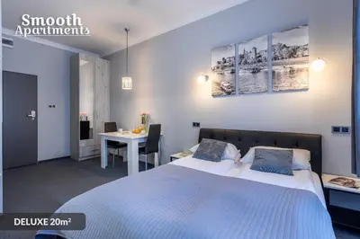 a bedroom with a bed and a desk and a table at SMOOTH Elegant Apartments KRAKÓW Old Town in Kraków