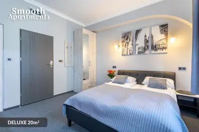 a bedroom with a large bed with a blue blanket at SMOOTH Elegant Apartments KRAKÓW Old Town in Kraków